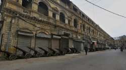 A private security guard walks through a market closed due to new restrictions announced by provincial government to help control the spread of the coronavirus, in Karachi, Pakistan.