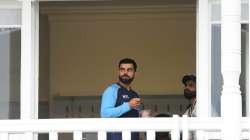 India captain Virat Kohli looks on from the dressing room as play is delayed during day five of the First Test Match between England and India at Trent Bridge on August 08, 2021 in Nottingham