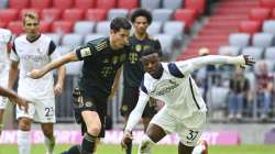 Munich's Robert Lewandowski , left, and Bochum's Armel Bella-Kotchap challenge for the ball during a German Bundesliga soccer match between Bayern Munich and VfL Bochum in Munich, Germany, Saturday, Sept.18