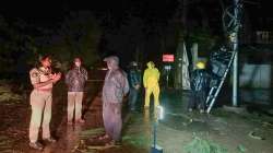 Police personnel and locals at a site after a tree fell down due to heavy winds induced by Cyclone Gulab, in Srikakulam district.