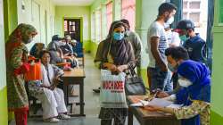 Teachers and students wait for a dose of COVID-19 vaccine during a special vaccination drive for them, at a school in Srinagar.