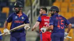 Afghanistan's Naveen-ul-Haq watches the ball as India's Rohit Sharma, right, and KL Rahul run betwee