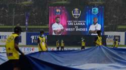 Sri Lankan ground staff brings in covers as it rains during the day three of the first test cricket 