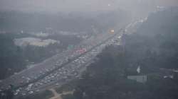 Vehicles ply on road amid low visibility due to a thick layer of smog, in New Delhi.