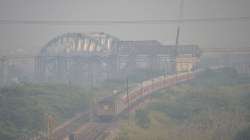 Ghaziabad: A train makes its way amid low visibility due to a thick layer of smog, in Ghaziabad on Friday