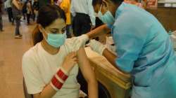 A nurse administers a Covid-19 vaccine shot to a woman. 