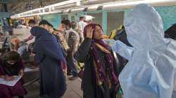 A health worker takes a swab sample of a traveler to test for COVID-19 at a railway train station.