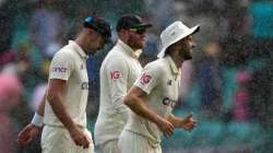 England's James Anderson (far left), Jonny Bairstow (centre) and Mark Wood walk off the field as rai