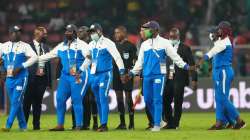 Referee Bamlak Tessema of Ethiopia, center, and his officials are shielded by security personnel.