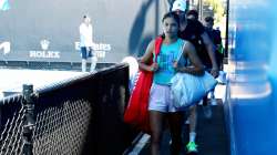 Emma Raducanu walks to her practice court with her coach Torben Beltz prior to a practice session at