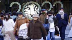 People wearing protective masks to help curb the spread of the coronavirus walk along a pedestrian crossing Tuesday, Jan. 18, 2022, in Tokyo.