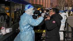 A man gets a swab for the COVID-19 test to meet traveling requirements at a mobile coronavirus testing facility outside a commercial office buildings in Beijing.