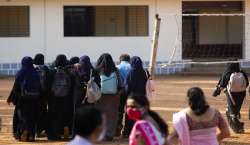 Girl students who were barred from entering their classrooms for wearing hijab, a headscarf used by Muslim women, arrive at their college in Udupi,?