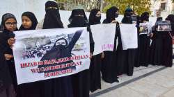 Muslim women holding placards participate in a mass prayer congregation, in solidarity with Muslim girl students of Karnataka over hijab issue, at Eidgah Ujale Shah at Saidabad, in Hyderabad, Wednesday, Feb. 9, 2022.