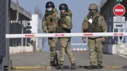 Ukrainian border guards stand at a checkpoint from territory controlled by Russia-backed separatists to the territory controlled by Ukrainian forces in Novotroitske, eastern Ukraine, Monday, Feb. 21, 2022.