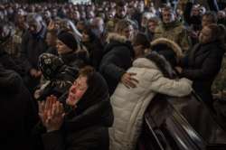 Relatives and friends attend a funeral ceremony for four of the Ukrainian military servicemen, who were killed during an airstrike in a military base in Yarokiv, in a church in Lviv, Ukraine