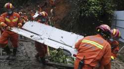 Search and rescue workers carry pieces of debris that were recovered at the China Eastern flight crash site in Tengxian County in southern China's Guangxi Zhuang Autonomous Region on Thursday, March 24, 2022.?