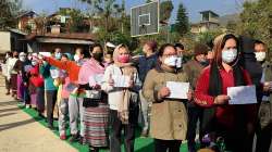 Voters holding their identification cards stand in a queue to cast their votes for the second phase of Manipur Assembly elections, in Senapati.?