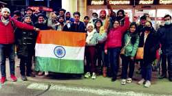 Indian nationals hold the tricolor before boarding a special Air India flight, evacuating Indians from war-torn Ukraine, in Bucharest. (FEB. 26, 2022)