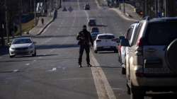 A police officer stands guard at a road leading to central Kyiv, Ukraine, Monday, Feb. 28, 2022.