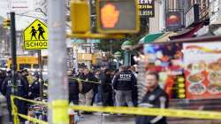 New York City Police Department personnel gather at the entrance to a subway stop in the Brooklyn borough of New York, Tuesday, April 12, 2022.