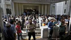 Members of media, lawyers and political workers gather at the main entry gate of Supreme Court during a break of the hearing of petitions for dissolving parliament by country's Prime Minister, in Islamabad, Pakistan.