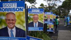 Volunteers stand outside a polling station as they wait for Australian Prime Minister to vote in Sydney