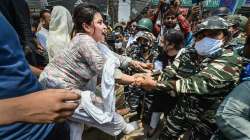 Security personnel attempt to stop locals staging a protest in front of a Municipal Corporation of Delhi (MCD) bulldozer at Shaheen Bagh area, during an anti-encroachment drive, in New Delhi, Monday, May 9, 2022.