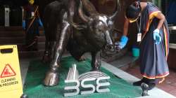 A woman cleans a bronze statue of a bull outside the BSE in Mumbai.