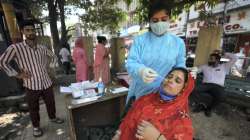 A healthcare worker collects a swab sample of a woman for Covid-19 testing amid a surge in coronavirus cases.