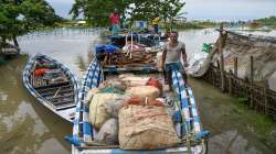 Flood-affected villagers use boats to shift to safer areas after heavy rainfall in Morigaon on Sunday, June 19, 2022.