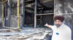 A man shows charred remains after a fire at Uphaar Cinema, which has been shut since 1997 following a blaze that killed 59 people, in New Delhi, Sunday.