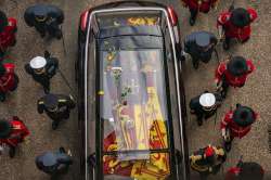 The queen’s flag-draped coffin was lowered into the royal vault underneath the chapel, joining her father George VI, and her husband, the Duke of Edinburgh, on Monday evening.