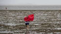 Curious sightseers walk in the receding waters of Tampa Bay due to the low tide and tremendous winds from Hurricane Ian in Tampa, Fla., Wednesday, Sept. 28, 