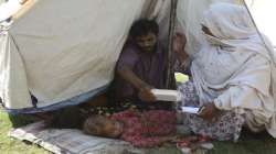 Rubina Bibi, 53, right, sits near her family after being taken to a refugee camp. 