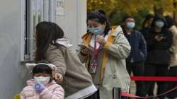 Residents line up to get their routine COVID-19 throat swabs at a coronavirus testing site in Beijing, Tuesday, Nov. 8, 2022.