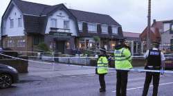 Police officers stand on duty at the Lighthouse Inn in Wallasey Village, near Liverpool, England, Sunday, Dec. 25, 2022.