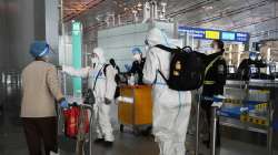 Passengers in protective gear are directed to a flight at a Capital airport terminal in Beijing