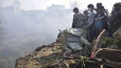 Nepalese rescue workers and civilians gather around the wreckage of a passenger plane that crashed in Pokhara, Nepal.