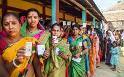 Voters show their identification cards as they wait in a queue to cast their votes at a polling booth during the Tripura Assembly elections, at Panisagar in North Tripura district