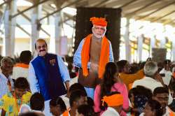 People holding cut-outs of Prime Minister Narendra Modi and Karnataka Chief Minister Basavaraj Bommai attend his public rally