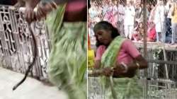 Snake wraps around hand of woman dancing in aarti at Hanuman temple