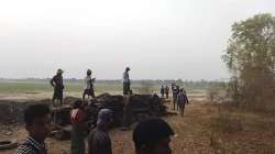 Men stand over a funeral pyre in Tar Taing village.