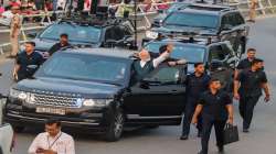 Prime Minister Narendra Modi waves at supporters during a roadshow. 