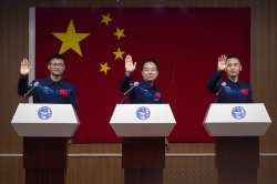 Chinese astronauts for the upcoming Shenzhou-16 mission, from left, Gui Haichao, Jing Haipeng, and Zhu Yangzhu wave as they stand behind glass during a meeting with the press at the Jiuquan Satellite Launch Center in northwest China.