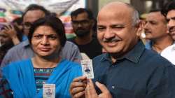  Manish Sisodia and his wife Seema Sisodia show their voter ID after voting at Pandav Nagar School on May 12, 2019.