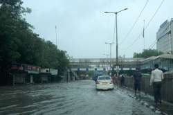 Vehicles pass through a waterlogged road near ITO