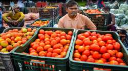 Tomato vendors wait for customers, at a vegetable market in Gurugram