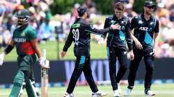 Mitchell Santner celebrates a wicket with teammates Mark Chapman and James Neesham.