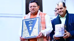 Uttarakhand Chief Minister Pushkar Singh Dhami leaves his residence with a copy of the Indian Constitution

